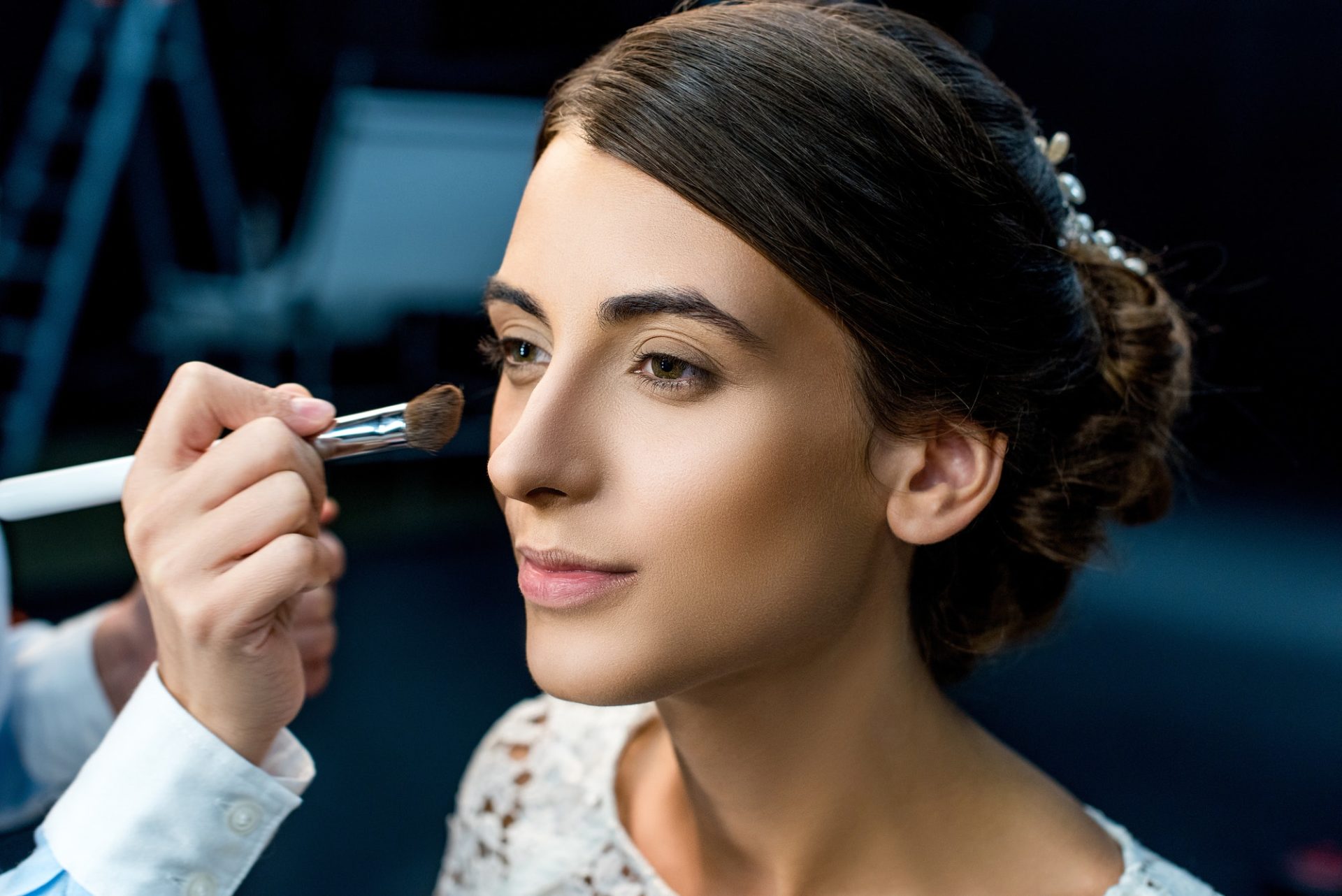 portrait-of-young-woman-getting-makeup-done-by-makeup-artist.jpg